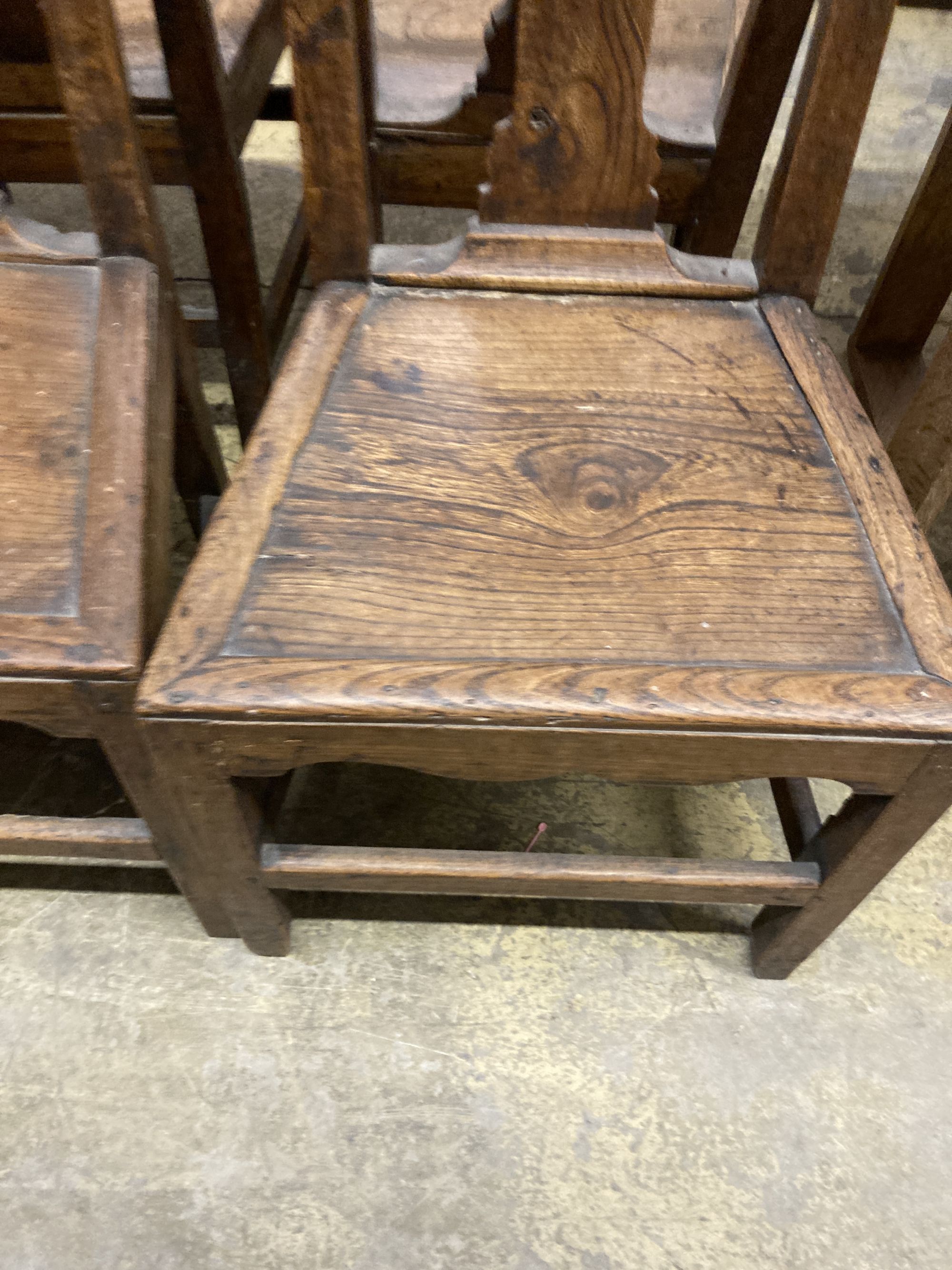 A set of four 18th century provincial elm wood seat dining chairs